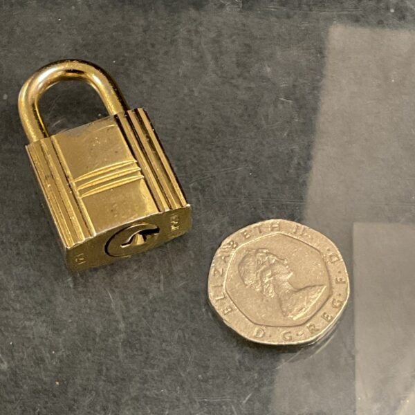 Vintage Hermes padlock in gold, a collectible luxury item.