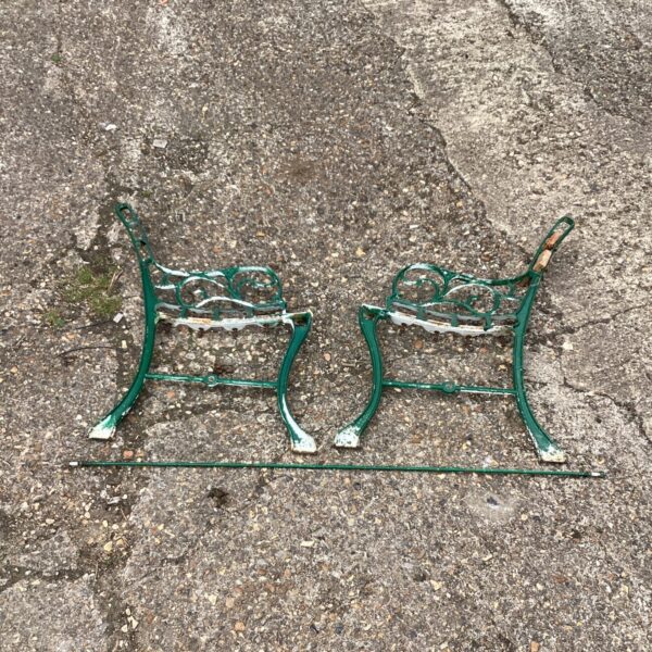 Vintage metal garden bench ends with decorative scrolling.