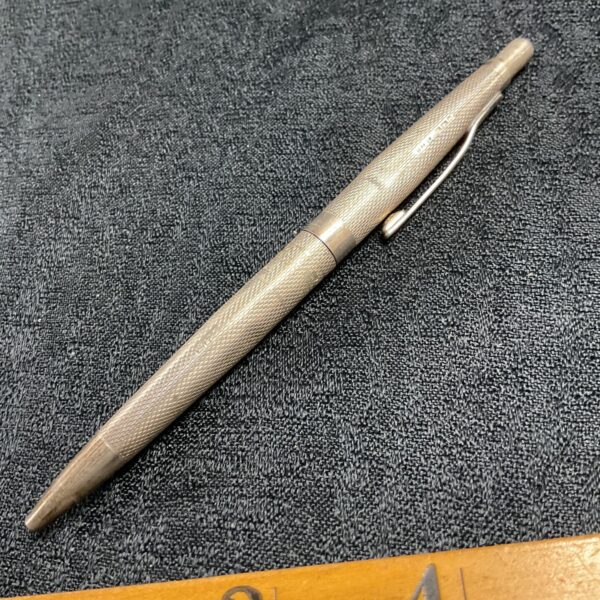 Hallmarked vintage silver pen with textured body.