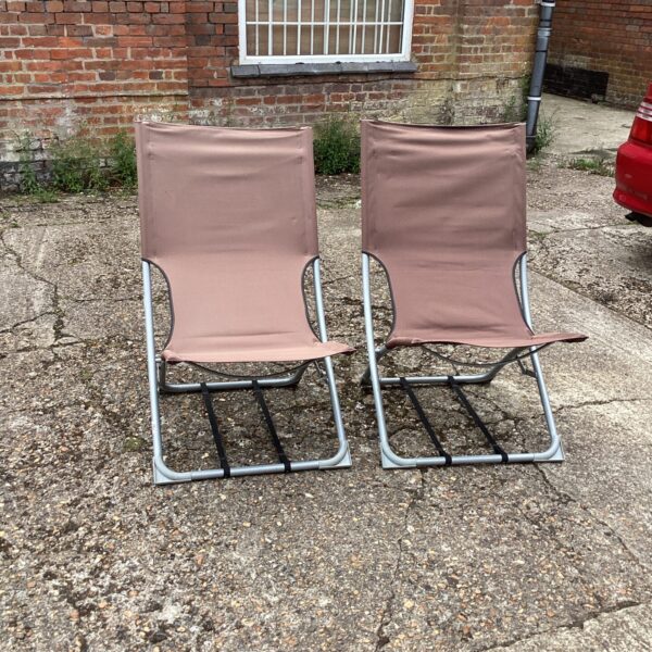 Two vintage folding garden chairs in a garden setting.