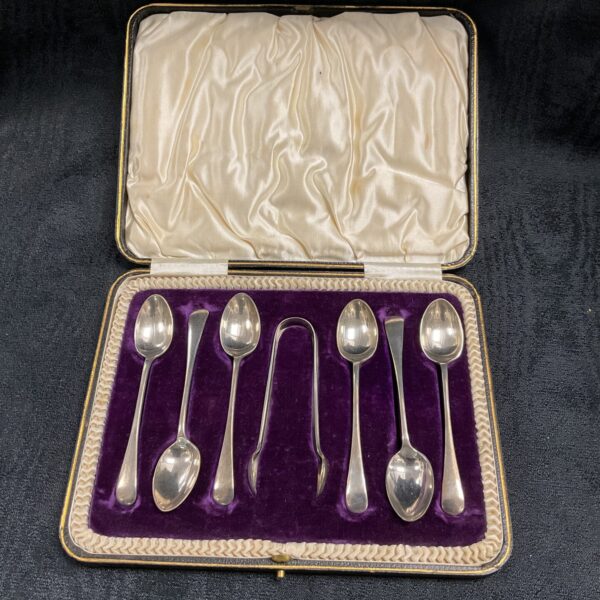 Antique silver coffee spoon set and tongs in a lined presentation box.