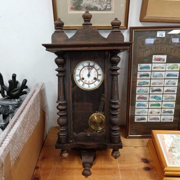 Antique oak wall clock with pendulum, vintage timepiece.
