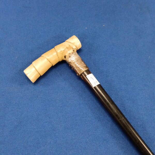 Detailed view of antique walking cane bone handle.