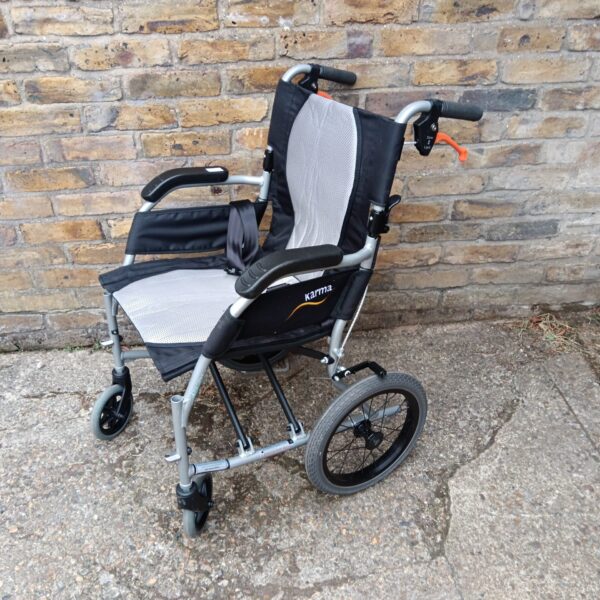 Silver Karma folding wheelchair with padded seat and backrest.