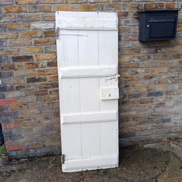 Antique 19th-century panelled door with iron fixings, ideal for restoration.