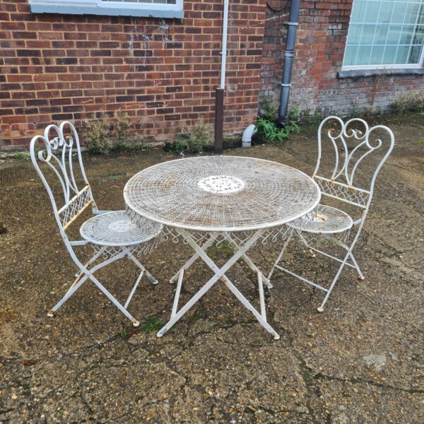 Vintage wrought iron garden set with folding table and chairs.