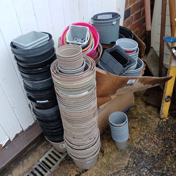 Large lot of assorted plastic plant pots for gardening and plant propagation.