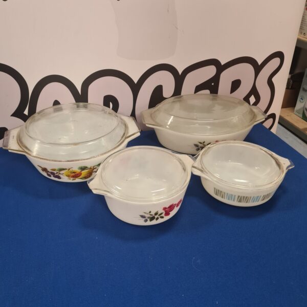 Vintage Pyrex casserole dishes with floral pattern on display.