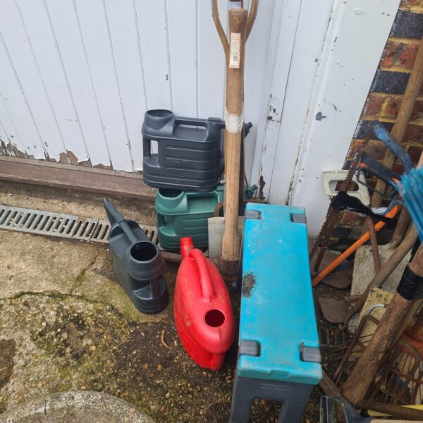 Garden tool bundle with watering cans and plastic bench.