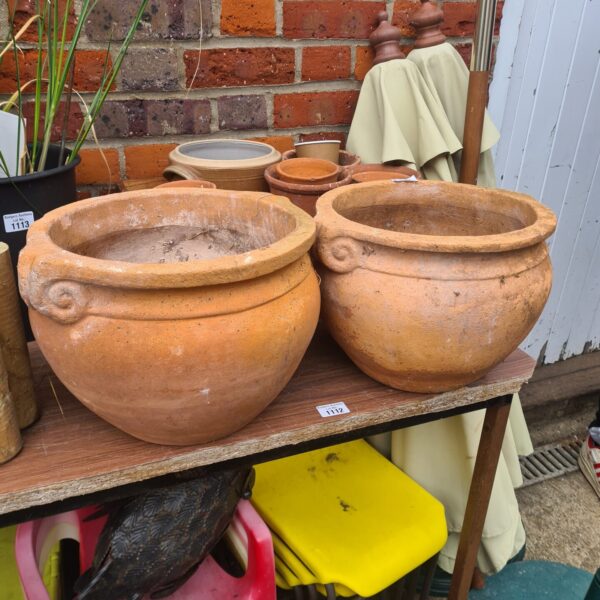Pair of weathered terracotta garden pots for outdoor planting.