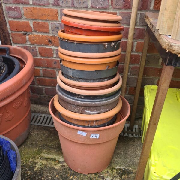 Assorted brown plastic garden pots stacked for storage.