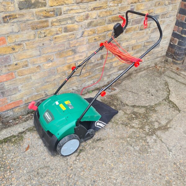 Vintage Qualcast garden mower in a garden setting.