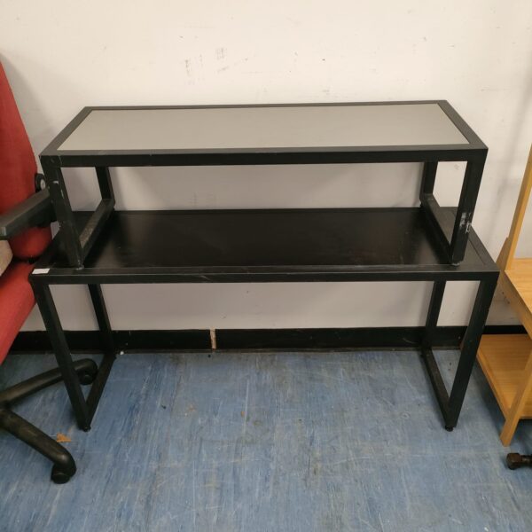 Industrial metal shelf unit with two tiers for storage and display.