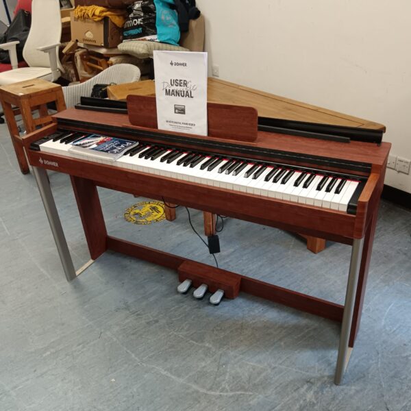 Donner 88 key digital piano with wooden cabinet and pedals.