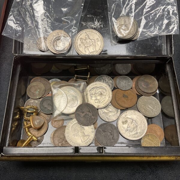 Assorted vintage coins inside a cash tin, collectible currency.