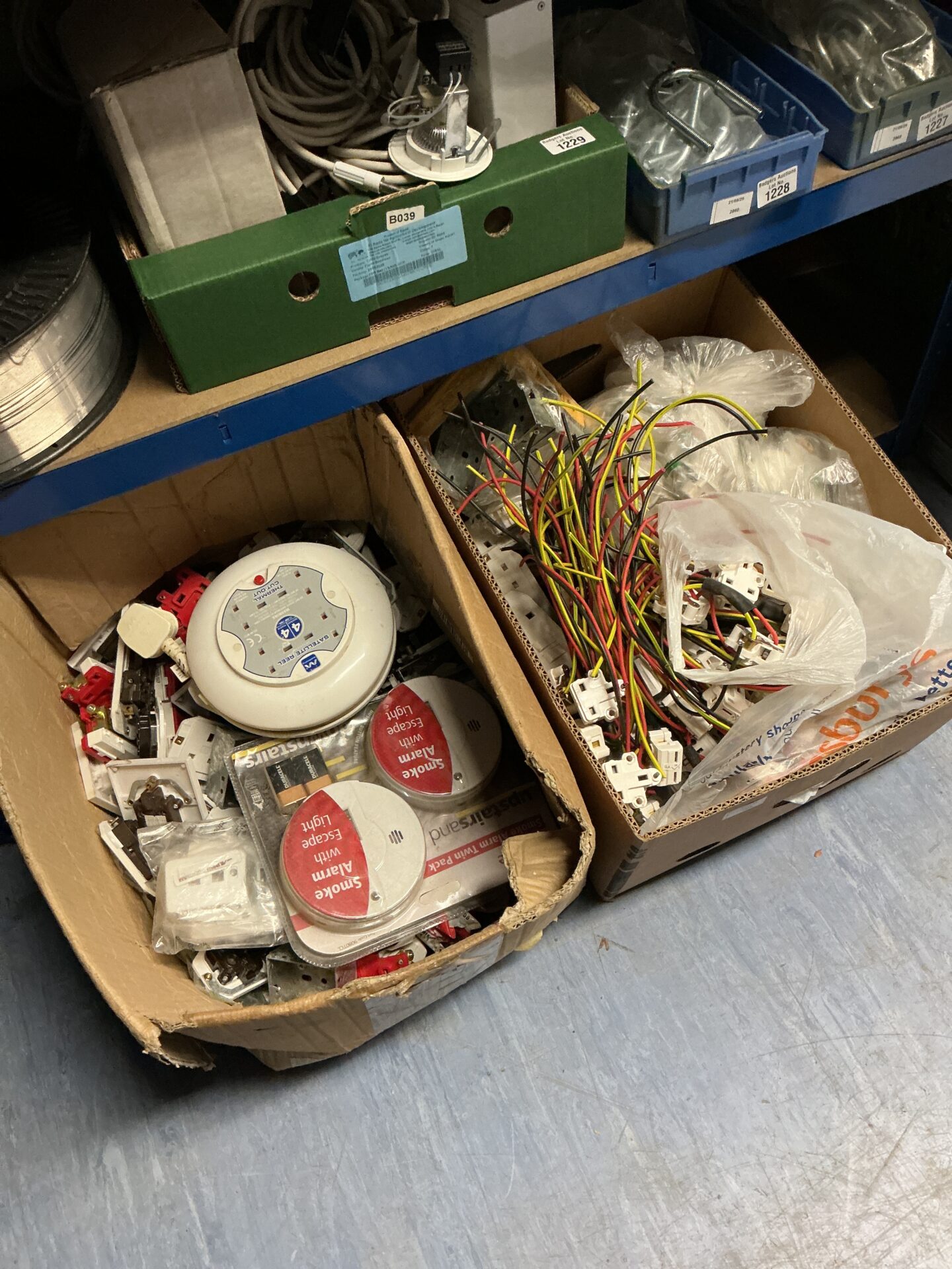 1176 Two boxes of electrical fittings, plug sockets and smoke alarms