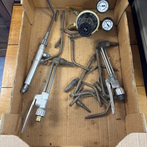 Assorted vintage welding torches and nozzles with a Saffire regulator.