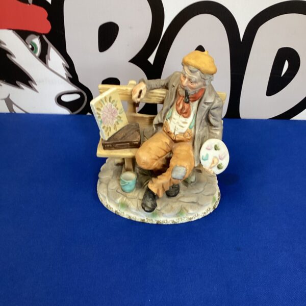 Vintage bisque porcelain artist figurine on blue background.