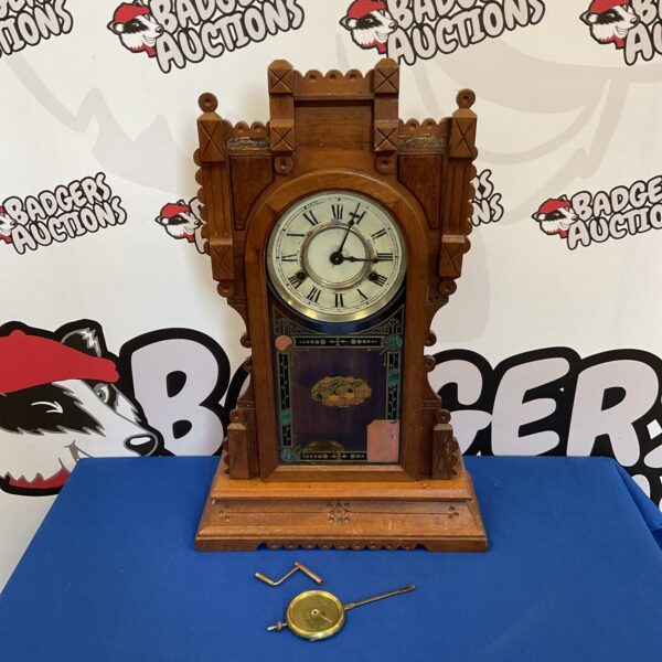 Vintage American wall clock with oak case and pendulum.