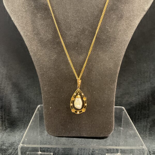 Delicate Art Nouveau pearl pendant necklace with floral design.