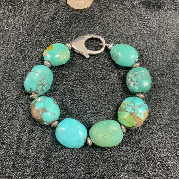 Vintage turquoise and silver bracelet with unique bead patterns.
