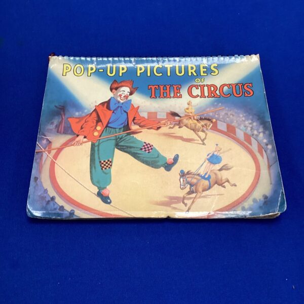 Vintage pop-up circus book cover with ringmaster illustration.
