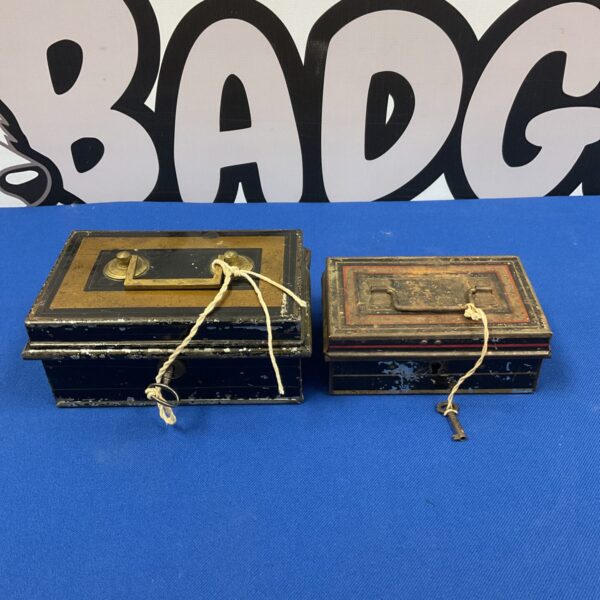 Two vintage tin money boxes with locks, front view.