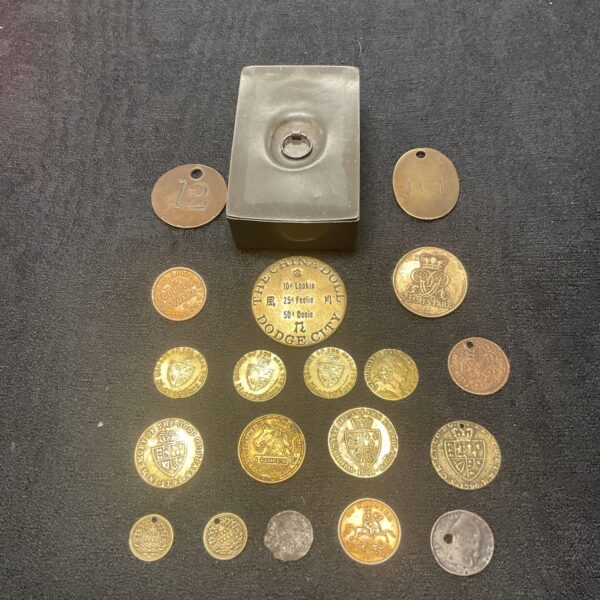 Antique pewter box with a collection of vintage gaming tokens.