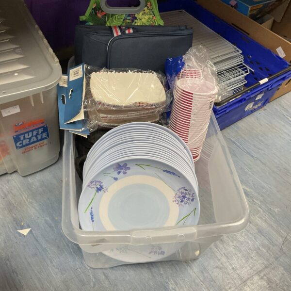 Mixed lot of disposable party supplies including floral plates and cups.