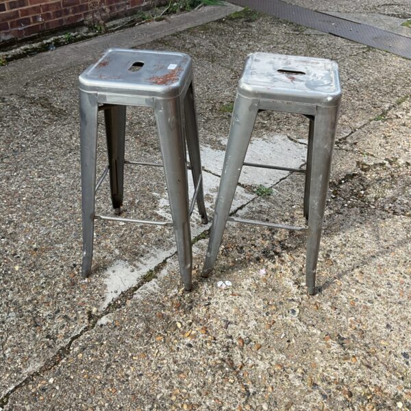 Pair of vintage metal bar stools with industrial design.