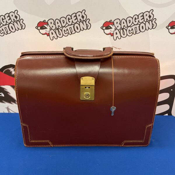 Vintage leather pilots bag with key, classic aviation accessory.