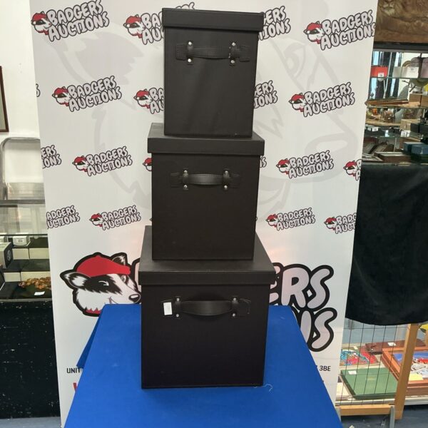 Set of three dark faux leather storage boxes.