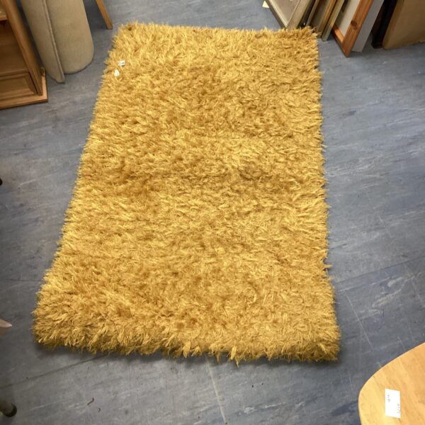 Bright yellow shag pile rug measuring 80x130cm for home decor.
