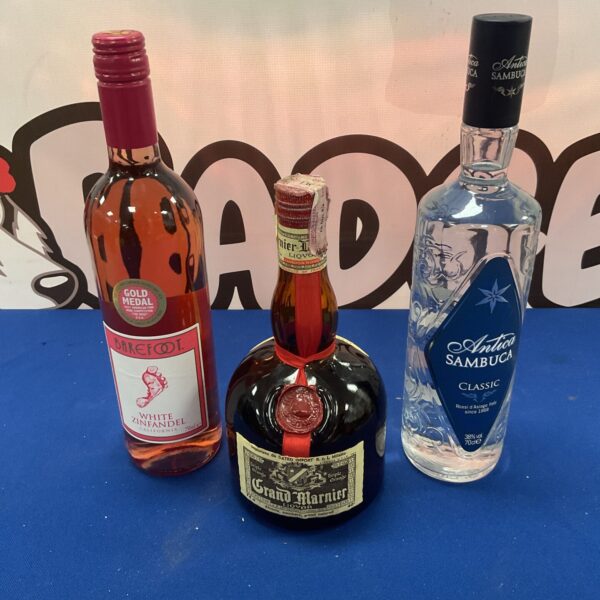 Mixed alcohol lot including Grand Marnier, Sambuca and white Zinfandel wine bottles.