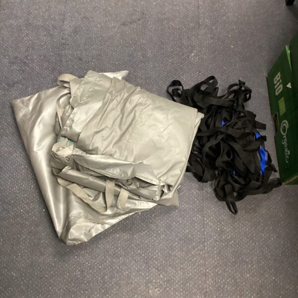 Used car cover with securing straps for vehicle protection.