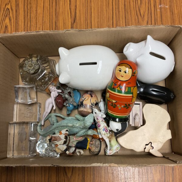 Vintage tray lot with paperweights, piggy banks and a Russian doll.