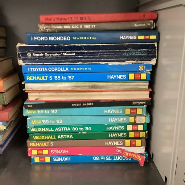 Collection of vintage Haynes car repair manuals for various models.