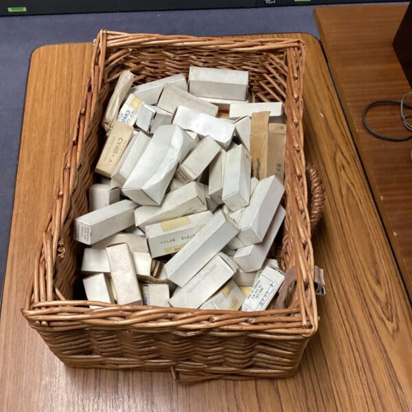 Wicker basket filled with vintage military valve components.