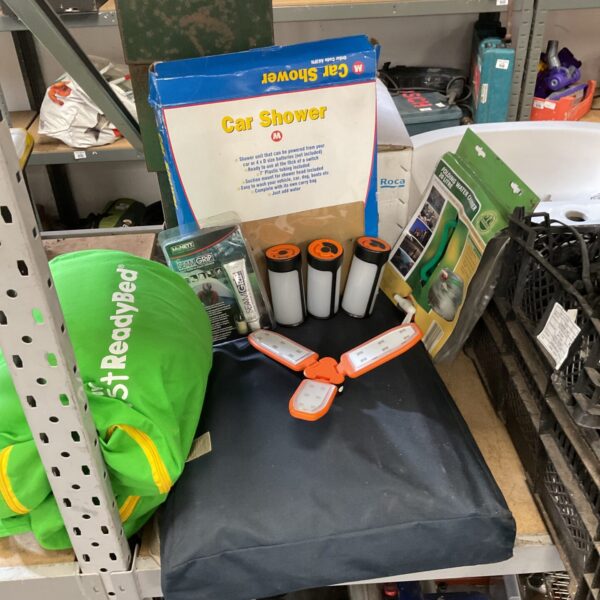 Camping equipment lot including car shower and shelving unit.