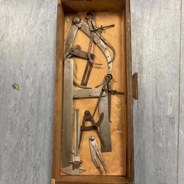 Vintage engineering measuring tools including calipers and dividers.
