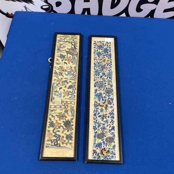 Framed vintage Japanese silk prints with detailed scenes.