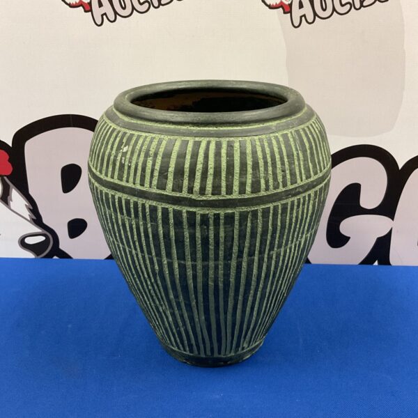 High-fired green and black pottery vase with textured ridges.