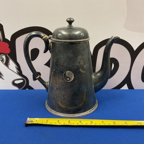Antique silver plate coffee pot with Ying Yang design, front view.