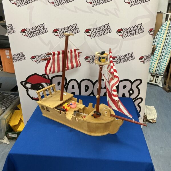 Vintage wooden sailing boat with plastic ducks on deck.