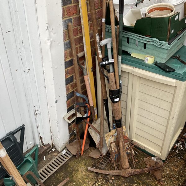 A lot of vintage garden tools including a spade and rake.