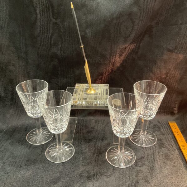 Waterford crystal wine glasses and pen set displayed on dark background.