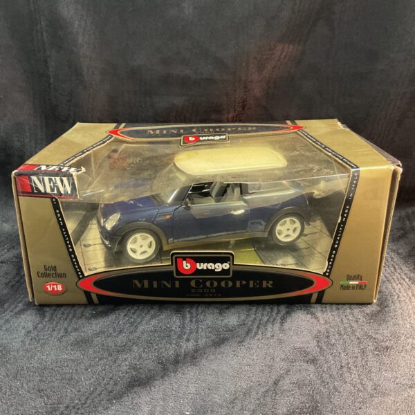 Side view of a red Burago 1/18 scale Mini Cooper diecast model car.