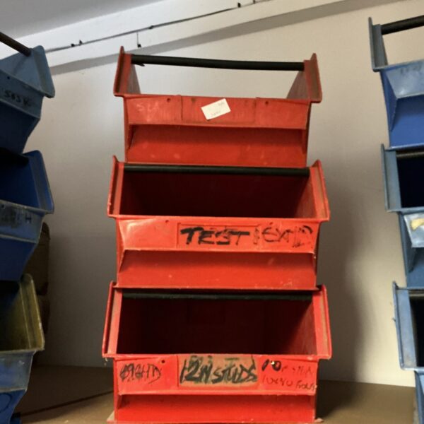 Red workshop storage tray with multiple compartments for tools and parts.
