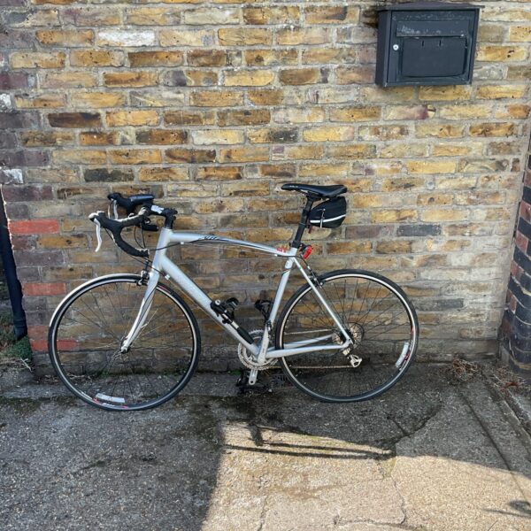 Silver Specialized Allez S500 racing bike on a brick wall.