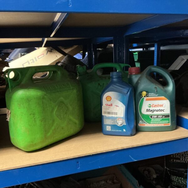 Lot of vintage petrol cans and partially used engine oil bottles.